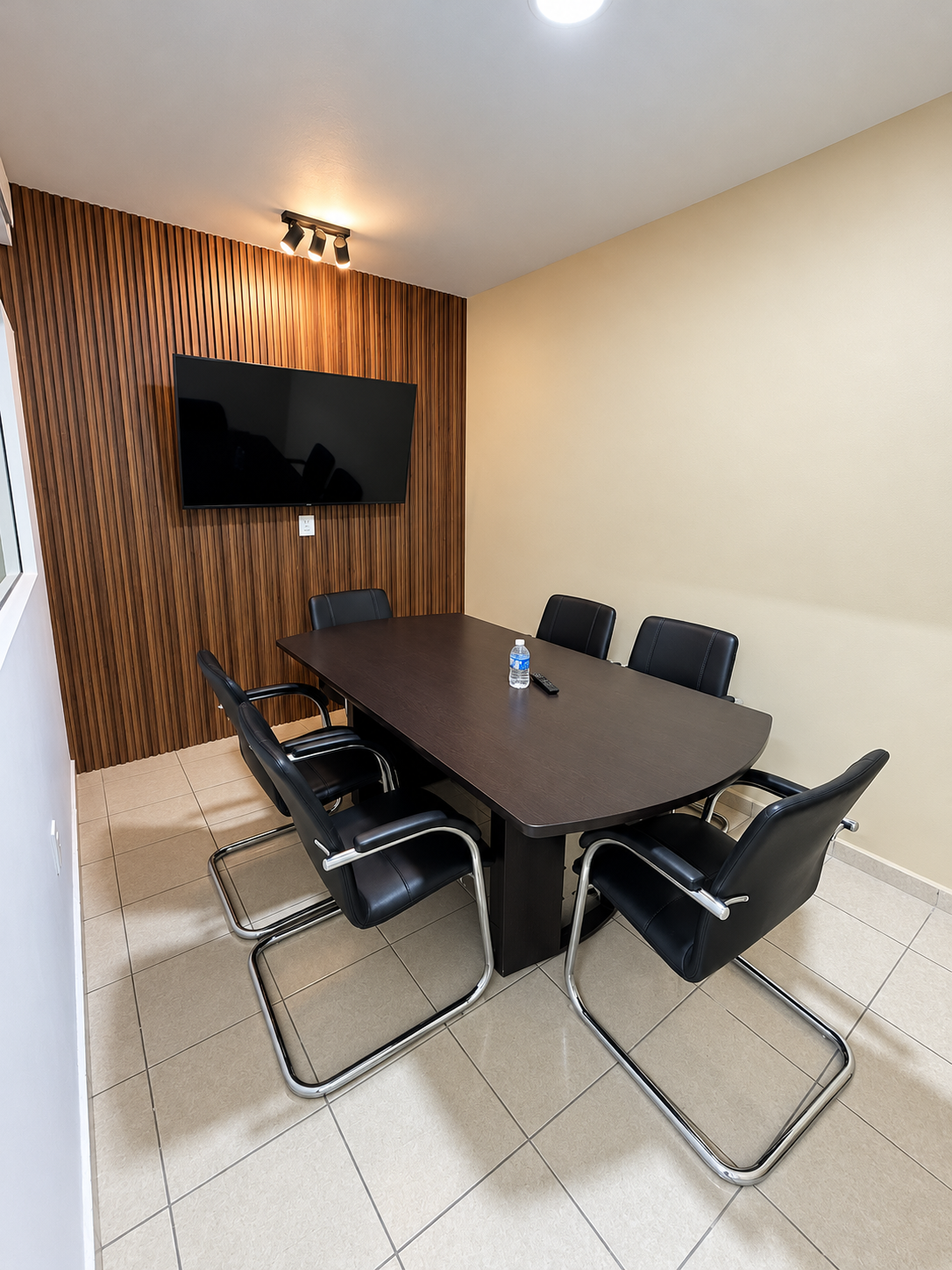 Sala de juntas de Leal y Abogados, con mesa de reuniones, sillas y pantalla